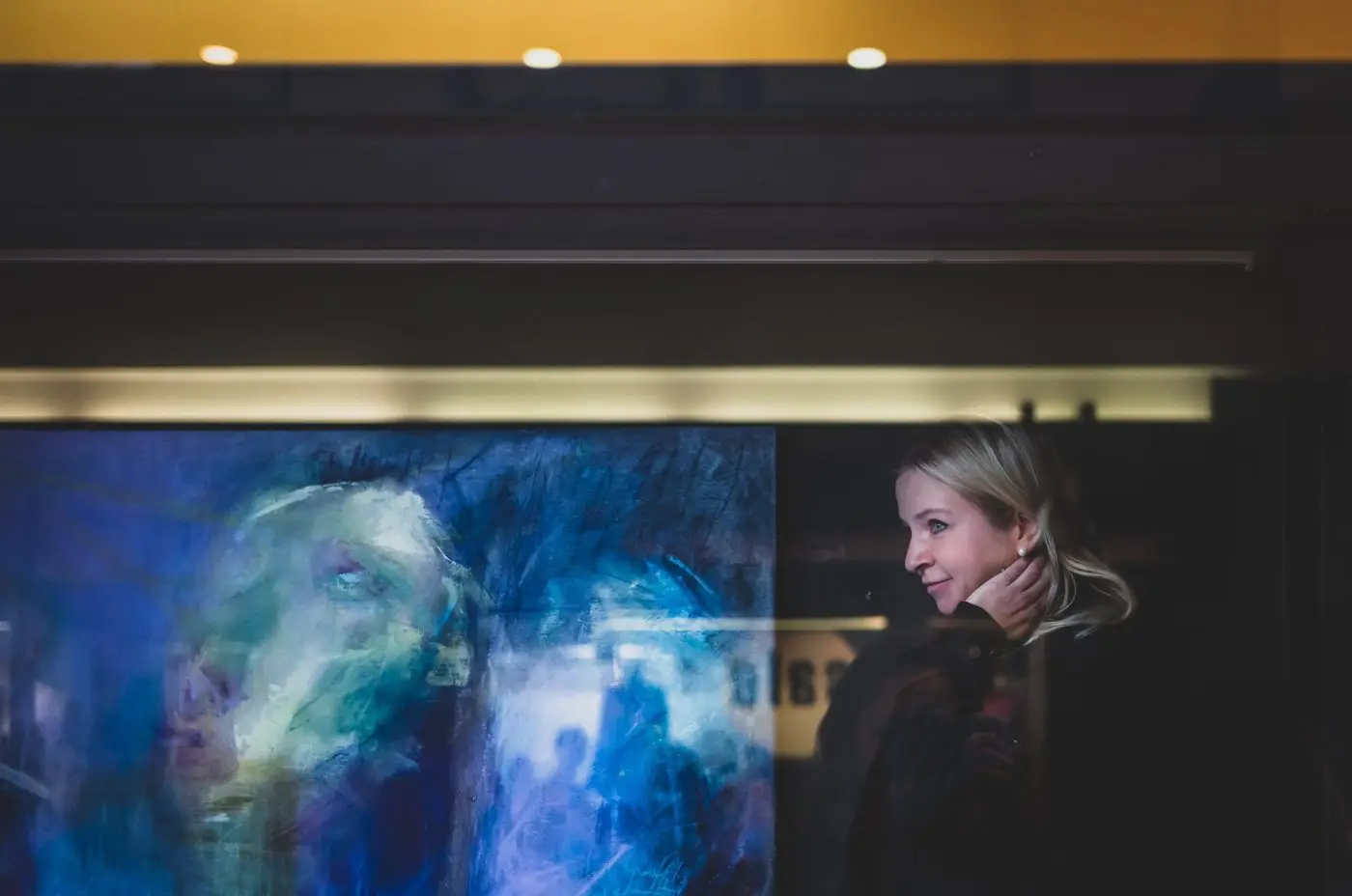 Lenka Kozlíková za výlohou galerie u modrého plátna